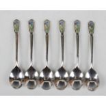 A set of six George V silver and enamelled coffee spoons, each terminal enamelled with a blue flower