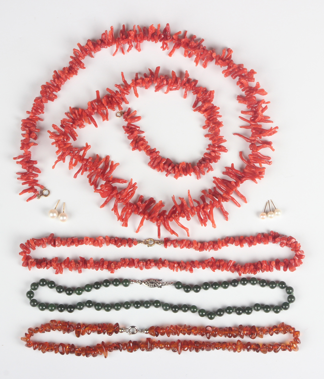 A single row necklace of nephrite beads, length 41cm, two single row necklaces of branch coral, a