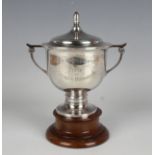 A George VI silver trophy cup and domed cover with ovoid finial above a squat circular body with