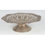 A sterling silver tazza with pierced decoration within a floral and scroll rim, on a pedestal