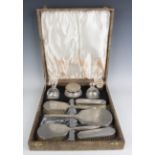 A George VI silver mounted engine turned eight-piece dressing table set, comprising two hairbrushes,