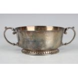 A George V silver circular two-handled bowl, on a circular dentil decorated foot, Birmingham 1934 by