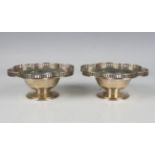 A pair of George V silver circular bonbon dishes, each lobed rim with raised pierced gallery, on a