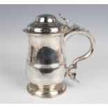 A George III silver tankard, the girdled baluster body with domed hinged lid and scroll handle, on a