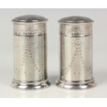 A pair of George V silver pepper casters, each cylindrical body and pierced dome top engraved with