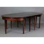 A George III mahogany dining table, formed from a pair of demi-lune ends and a matched drop-flap