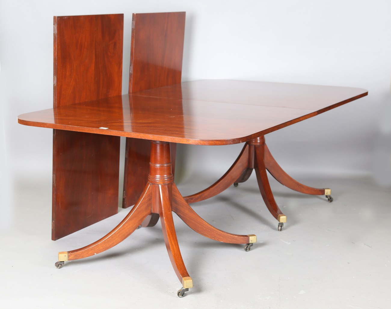 A 20th century George III style twin pillar mahogany 'D' end dining table, possibly by William