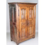 A 17th century French oak armoire, the two panelled doors carved with radiating paterae and