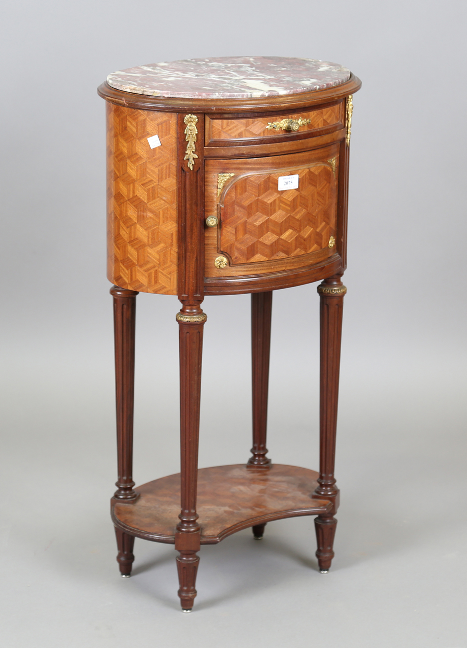 An early 20th century French parquetry kingwood oval bedside cabinet with gilt metal mounts and