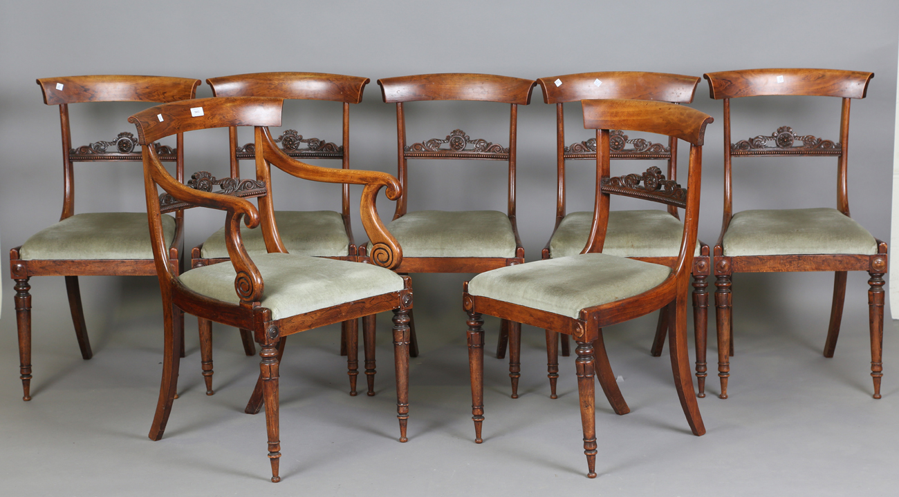 A set of seven Regency simulated rosewood beech framed dining chairs with carved centre rails,