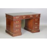 A late 19th/early 20th century walnut twin pedestal desk, the green leather top above an arrangement