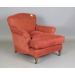 A modern Howard style armchair, possibly by George Smith, raised on turned legs and castors,