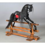 A modern black painted rocking horse by Stevenson Brothers, finely carved and fitted with a