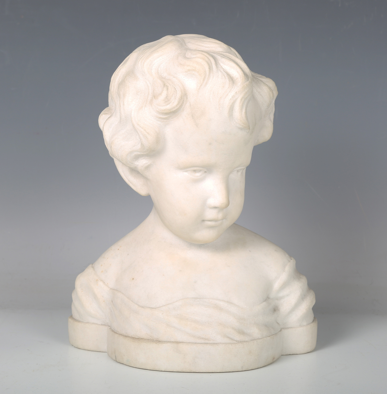 An early 20th century carved marble bust of a young boy, unsigned, height 24cm.Buyer’s Premium 29.4%