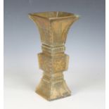 A 20th century Chinese brass vase of archaistic form, the angular body with engraved decoration,