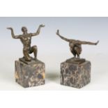 A pair of early 20th century brown patinated bronze figures of two nude men, each holding their arms