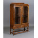 A George V oak glazed bookcase, fitted with two drawers, height 149cm, width 91cm, depth 32cm.