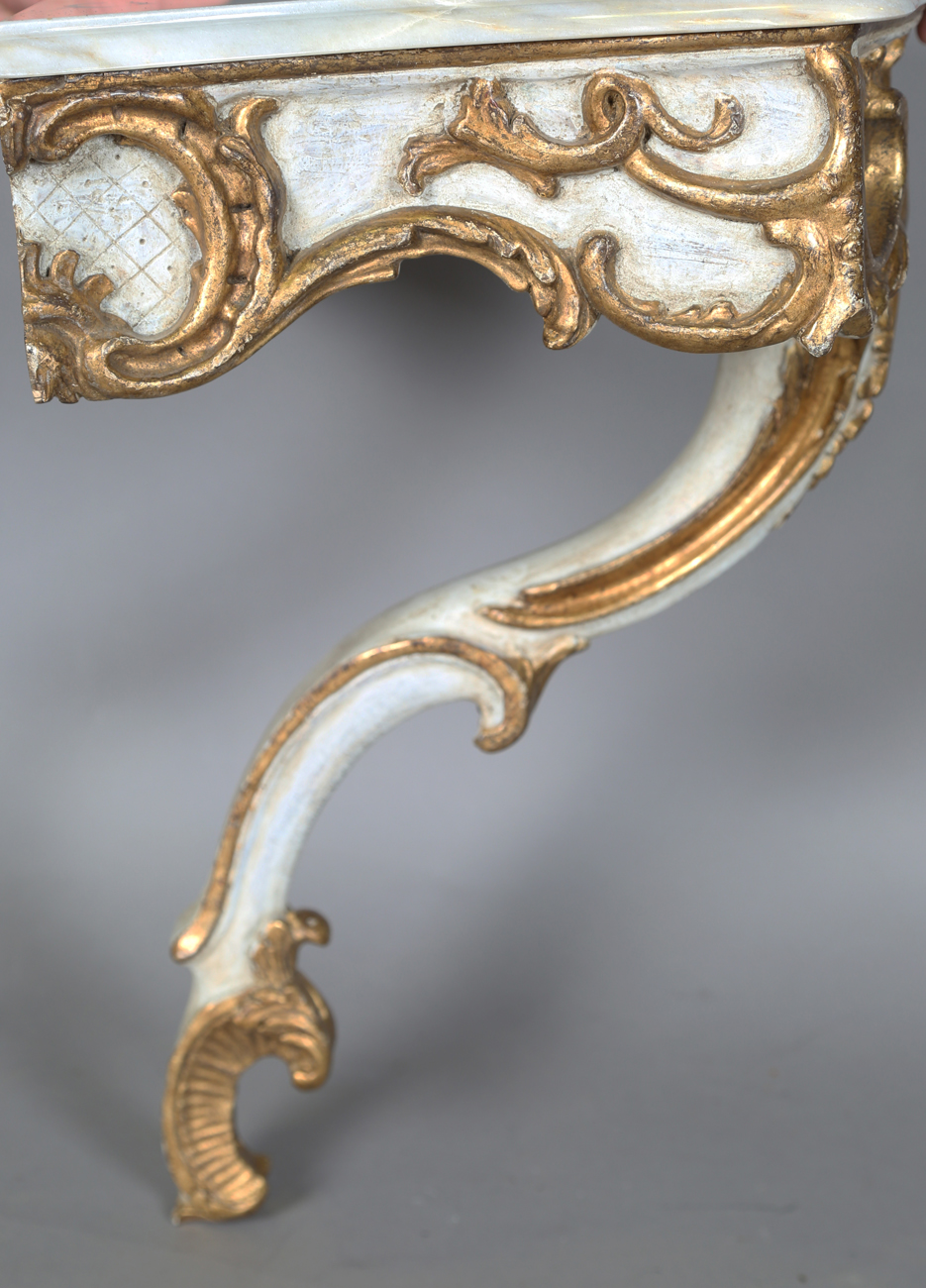 A pair of modern Rococo style white and gilt painted carved wooden console tables with shaped - Image 4 of 15