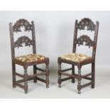 A near pair of 17th century oak Derbyshire chairs with carved backs and panelled seats, height