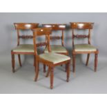 A set of four early Victorian mahogany bar back dining chairs with carved foliate centre rails,