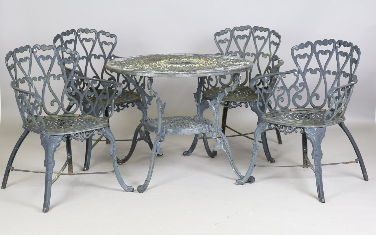 A 20th century cast metal circular garden table, height 66cm, diameter 87cm, and four matching