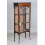 An Edwardian mahogany display cabinet with inlaid decoration and glazed door, on outswept square