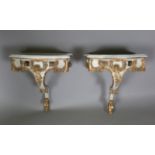 A pair of modern Rococo style white and gilt painted carved wooden console tables with shaped