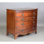 A late George III mahogany bowfront chest of four oak-lined drawers, the frieze with pull-out