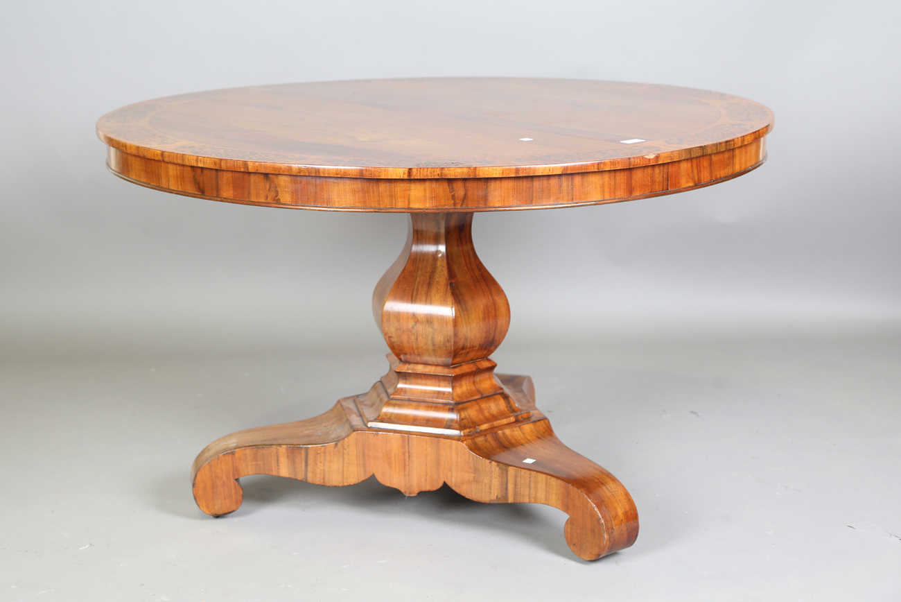 A mid-19th century walnut and foliate inlaid tip-top breakfast table, raised on a triform base,