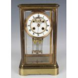 A late 19th/early 20th century French lacquered brass four glass mantel clock with eight day