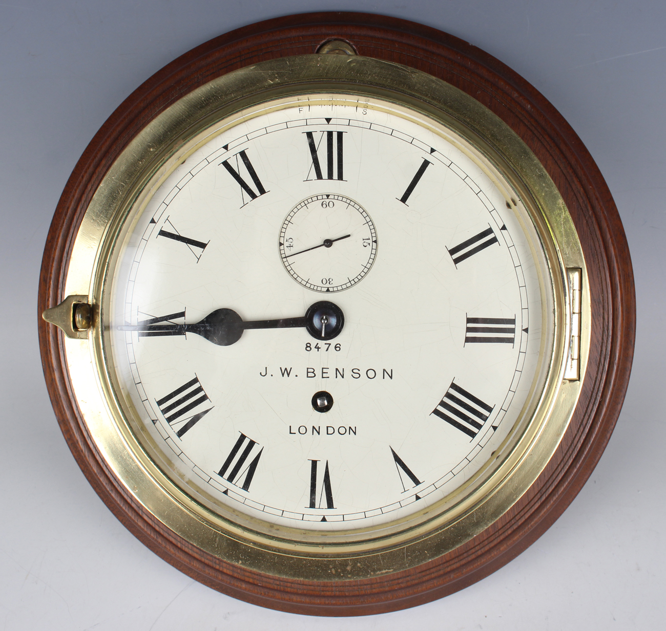 An early 20th century brass circular cased ship's bulkhead type timepiece, the brass four pillar