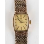 An Omega 9ct gold lady's bracelet wristwatch, the curved rectangular matt gilt dial with baton