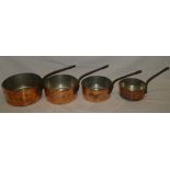 Four copper circular graduated saucepans with iron handles