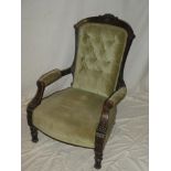 A Victorian carved walnut open arm easy chair upholstered in green buttoned fabric on turned