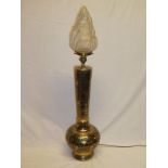A 20th century middle Eastern brass table lamp with floral decoration and flaming torch glass shade