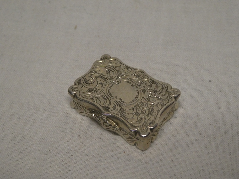 A Victorian silver rectangular vinaigrette with hinged inner pierced cover and engraved scroll