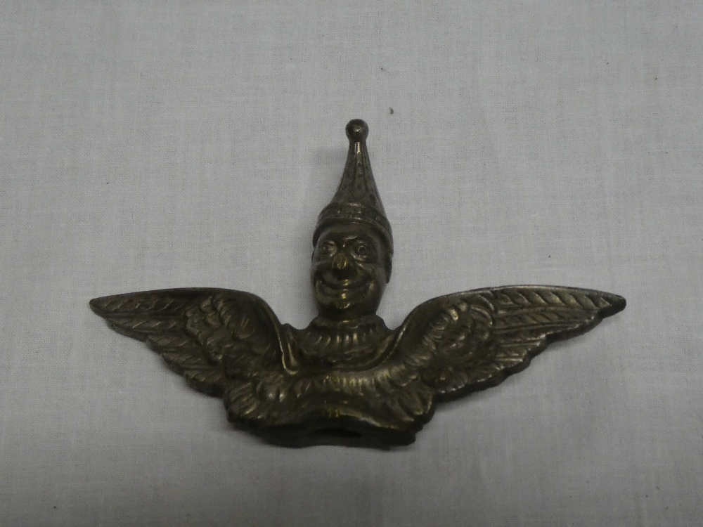 An old plated brass emblem in the form of a winged figure,