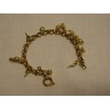 A 9ct gold chain link charm bracelet supporting numerous 9ct gold and other charms
