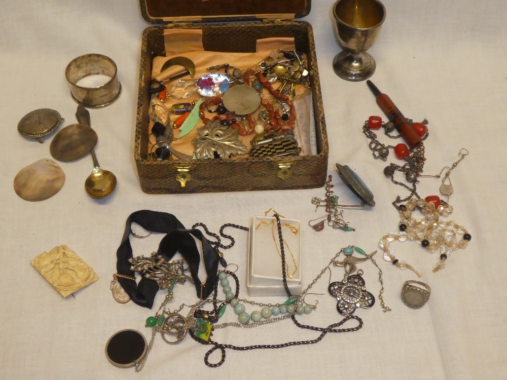 A box containing various costume jewellery together with silver egg-cup and napkin ring etc.