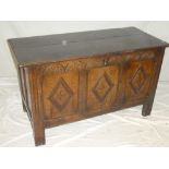 An 18th century carved oak rectangular coffer with triple panelled front and hinged lid on block