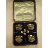 A set of four Victorian silver circular salts decorated in relief with scrolls,