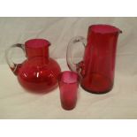 A cranberry tinted glass squat-shaped jug with loop handle,