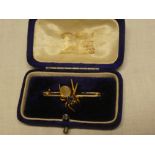 An unmarked gold bar brooch with spider decoration mounted with a sapphire and mother of pearl