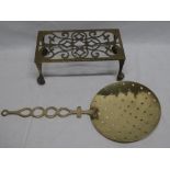 A 19th century brass milk skimmer with ornate handle and a brass rectangular kettle stand (2)