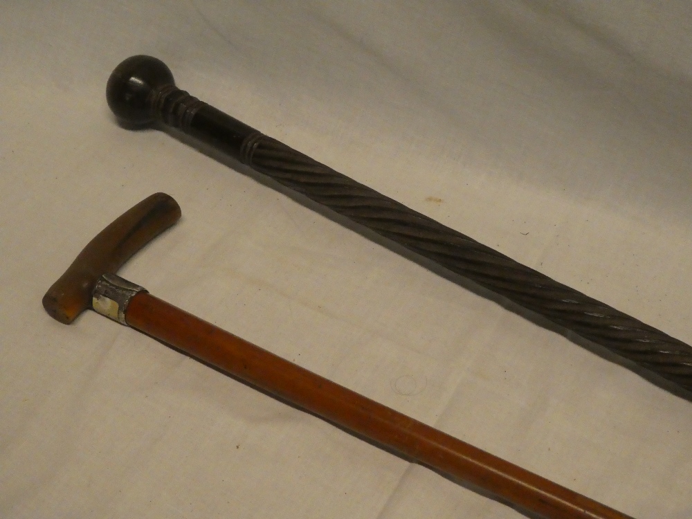 An African carved hardwood walking cane with spiral twist decoration and a gent's malucca and horn