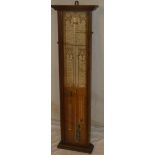 An old Admiral Fitzroy barometer with descriptive paper label and additional thermometer within oak