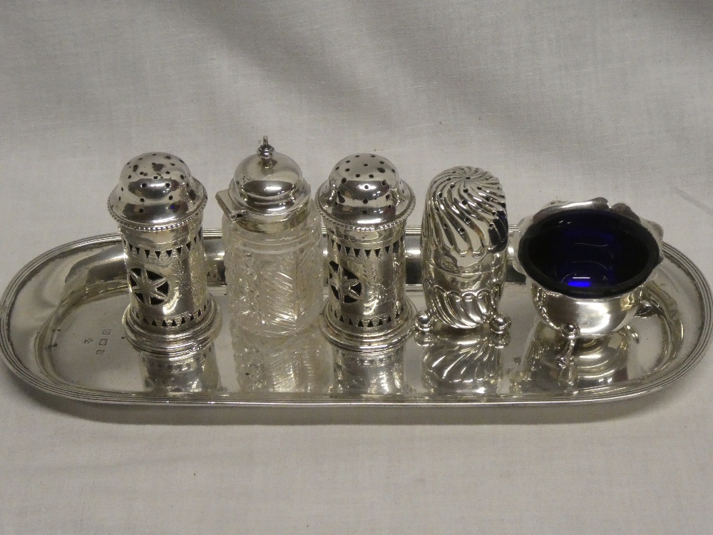 A pair of silver cylindrical pepperettes with engraved decoration,