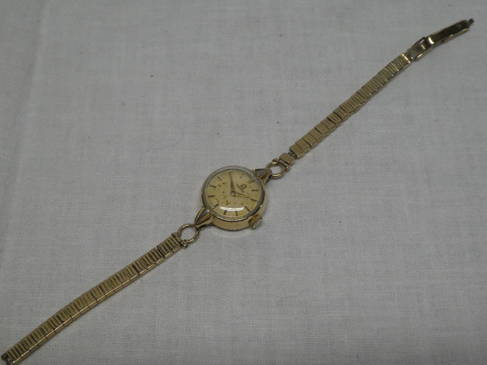 A ladies 9ct gold wrist watch by Omega with 9ct gold strap