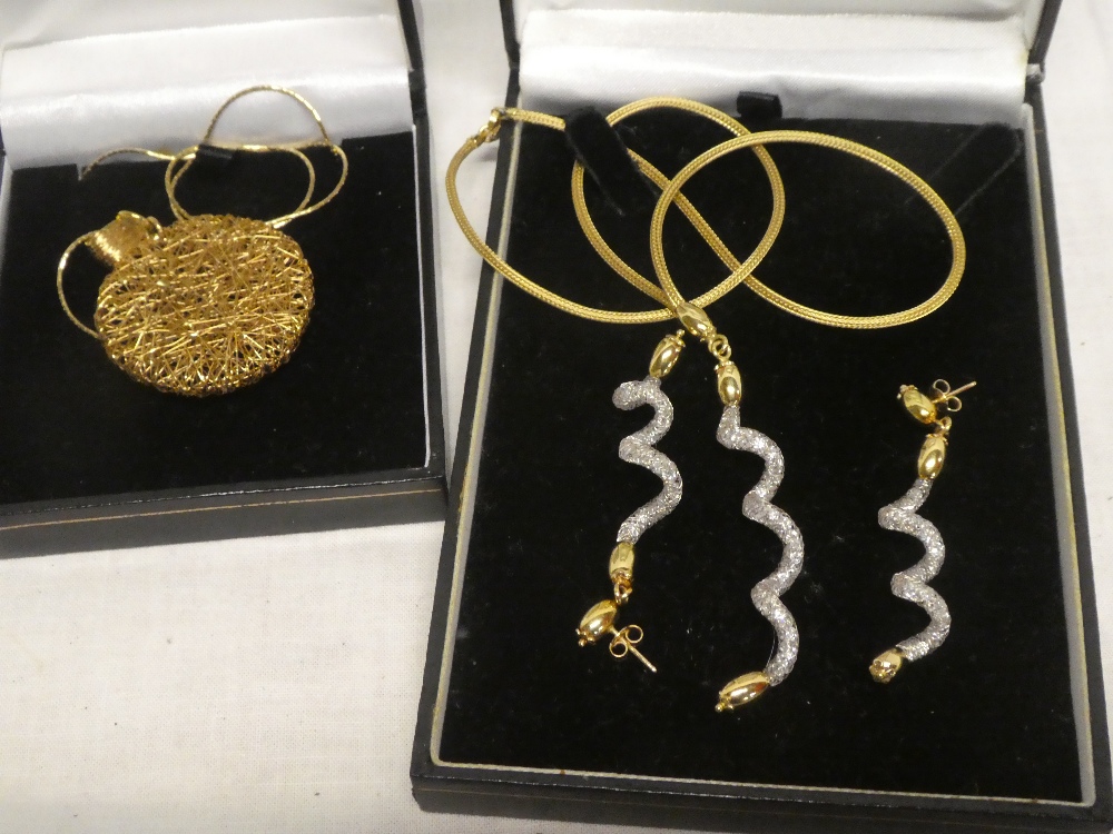 A 9ct gold circular spun pendant necklace with chain and an 18ct gold mounted necklace set spiral