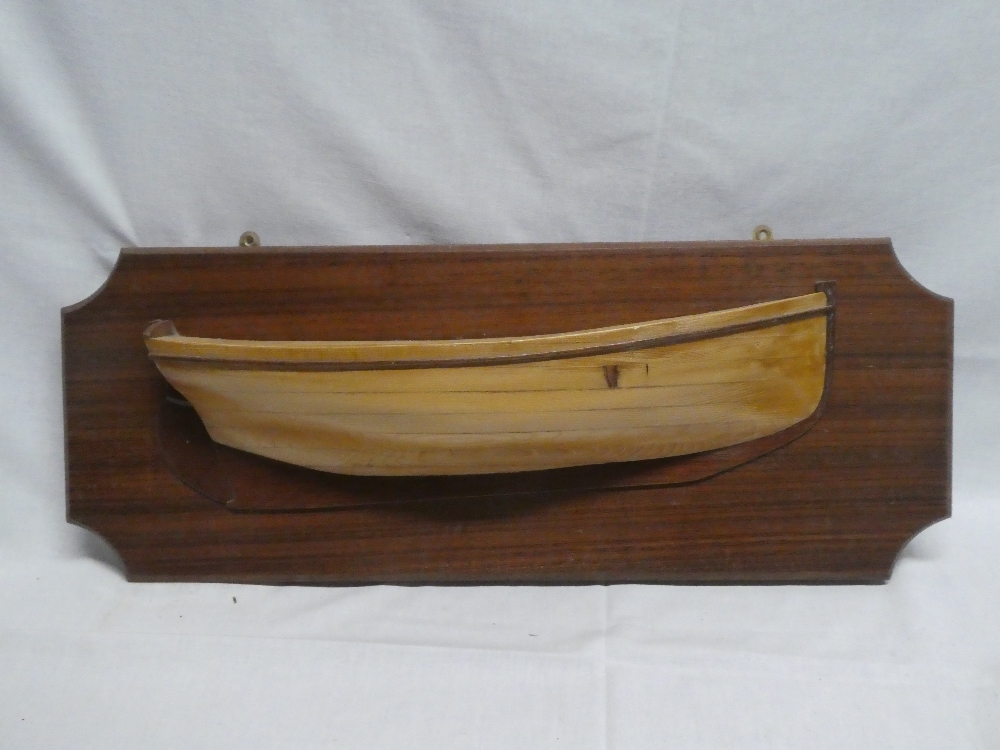 A good quality polished wood half boat model of a working sail boat by Henry Wylie mounted on a
